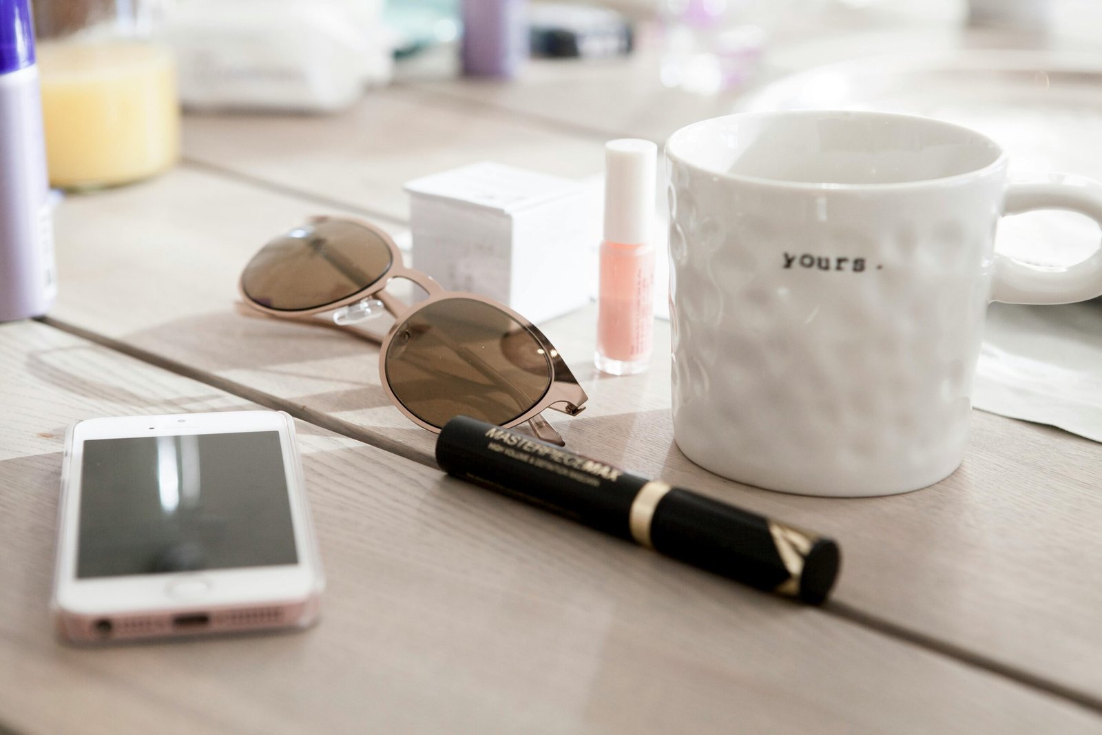 Modern summer essentials like sunglasses and coffee mug on a wooden table. Cozy and stylish setting.