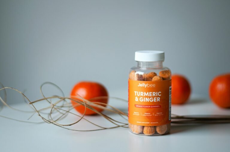 Vibrant still life of turmeric and ginger gummies with fresh oranges.