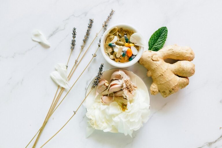 Flat lay of ginger, garlic, flowers, and supplements for holistic health.