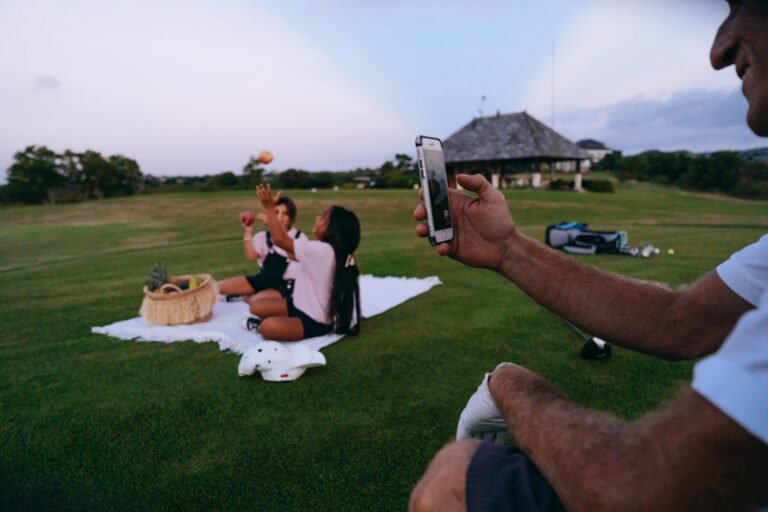 A family captures memories on a sunny picnic outing with a scenic golf course backdrop.