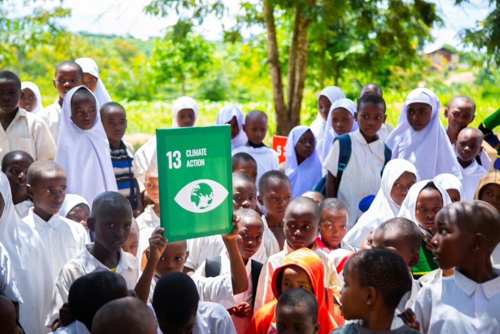 Group of children holding a Climate Action sign, promoting awareness for sustainable development.